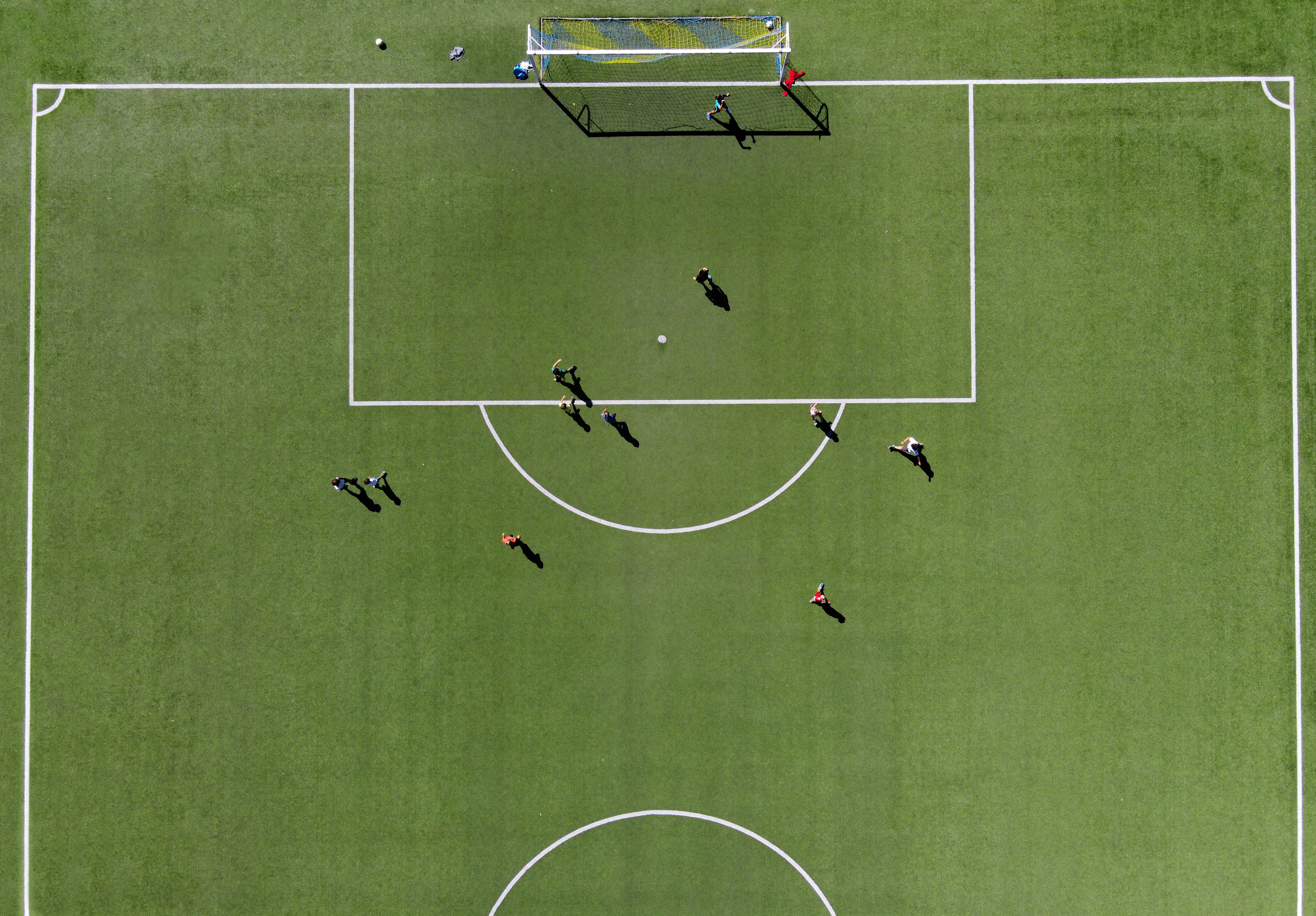 Bovenaanzicht voetbalveld met jongeren in training